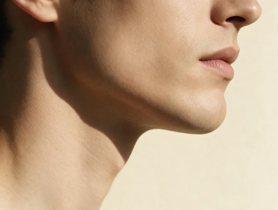 Three-quarter profile close crop of a defined jawline and neck